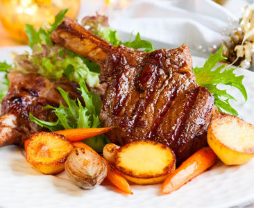 veal chop on a plate with root vegetables