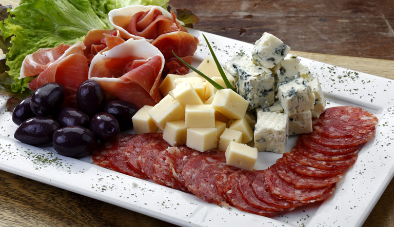 a collection of soft cheese wheels with grapes and nuts