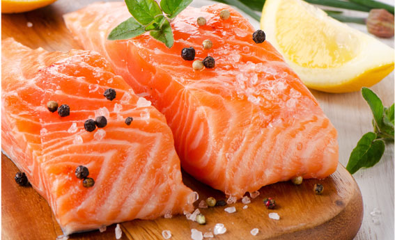 seasoned salmon steaks on a cutting board with lemon